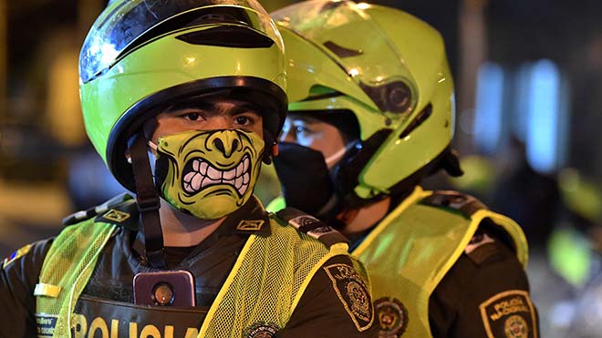 يستخدم ضباط الشرطة أقنعة الوجه كإجراء وقائي ضد انتشار الفيروس 